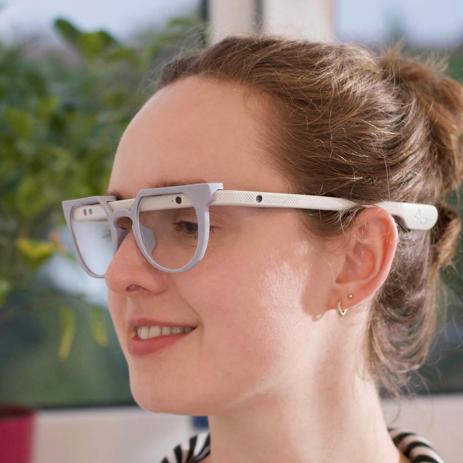 Seitliche Portraitaufnahme einer jungen Frau, welche die Augmenting-Glasses trägt.